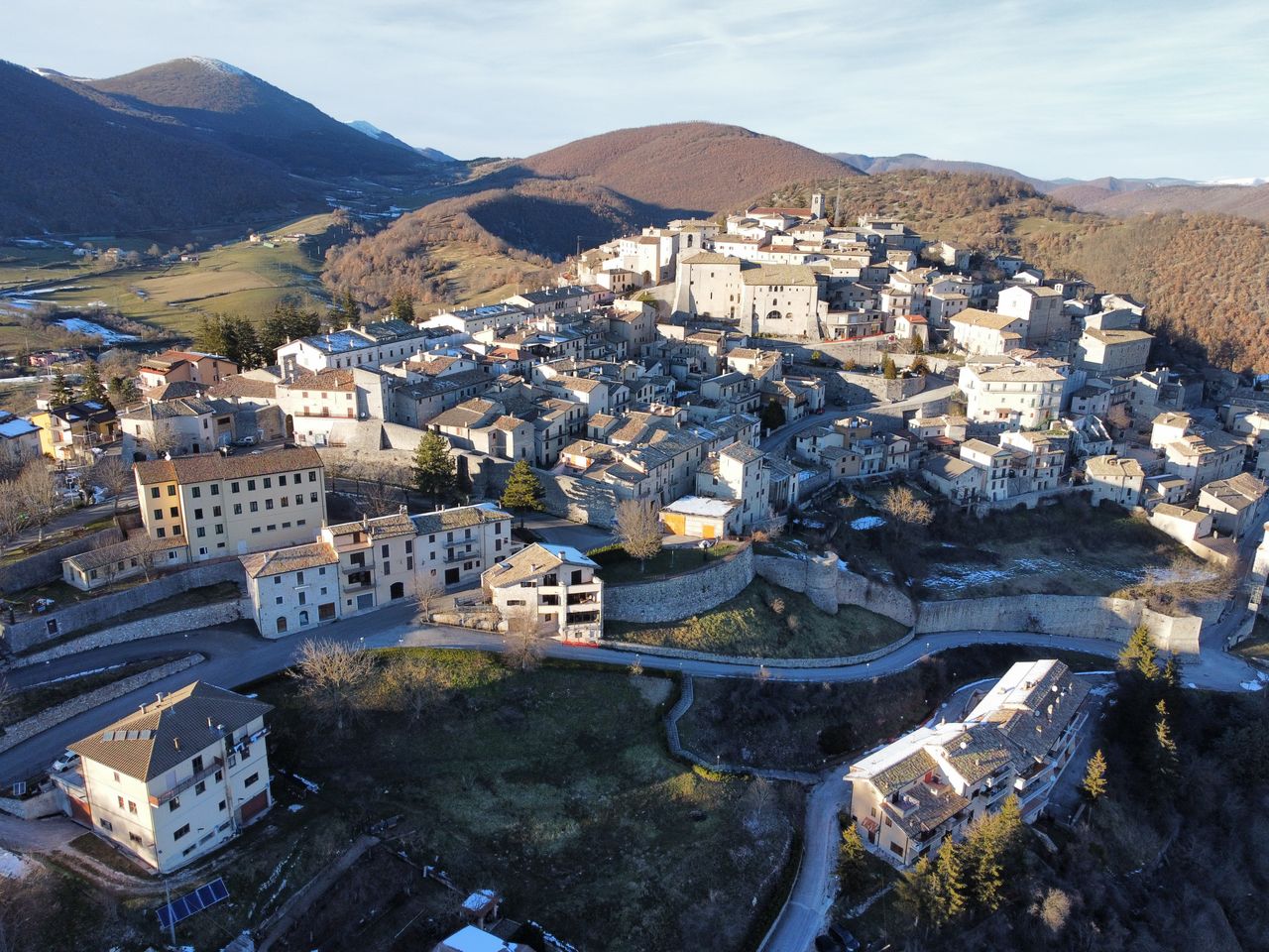 Drone shot of an Italian village showcasing rustic architecture and scenic landscape.