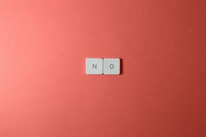Keyboard keys spelling 'NO' on a vibrant red background in a minimalist composition.